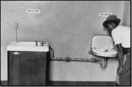 NORTH CAROLINA—A black man drinks at segregated water fountains, 1950. © Elliott Erwitt.jpg